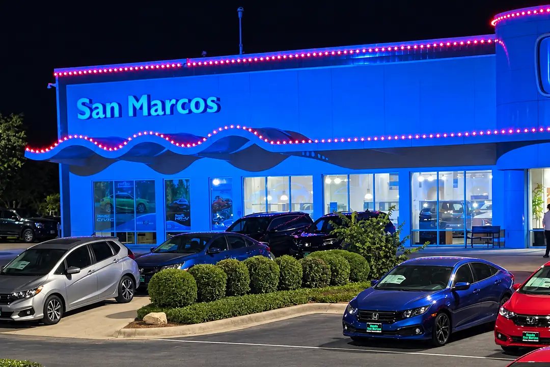 The San Marcos wing of the Honda dealership, a line of lights following the wave-shaped canopy over the showroom windows.