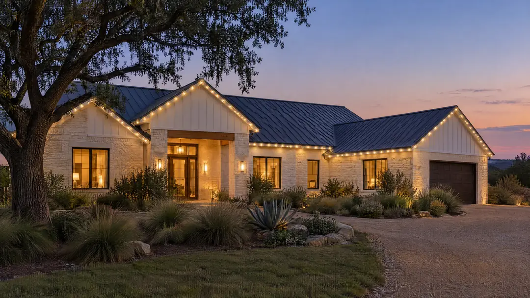 A limestone home at dusk with a slim white track along every roofline, lit by small, evenly spaced warm white LED pods.